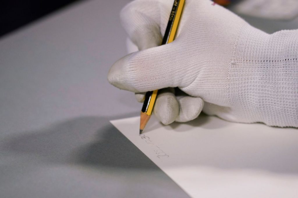 Eine fotografische Vorlage wird sorgfältig auf der Rückseite beschriftet.